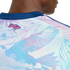 Close-up of a person's upper back wearing a light blue and pink tropical print jersey with a navy blue collar and a pink "Pura Vida" logo.