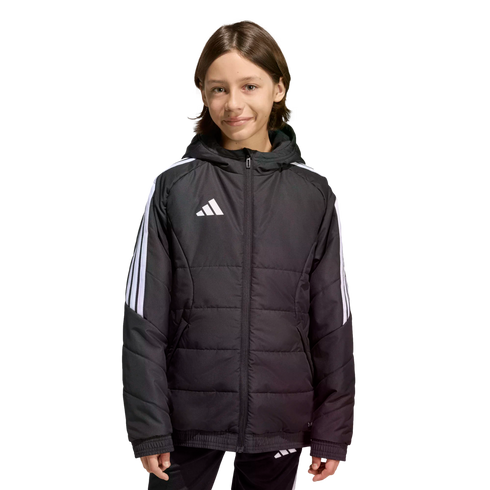 A young person wearing a black Adidas puffer jacket with white stripes on the sleeves and a logo on the chest, standing against a solid black background.