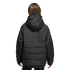 Rear view of a person in a black hooded puffer jacket with white sleeve stripes, standing against a plain black background.