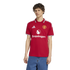 A man wearing a red Manchester United home football jersey with Snapdragon sponsorship and Adidas branding, paired with blue jeans, against a plain white background.