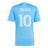 Back view of a light blue soccer jersey with "MESSI" and the number "10" in white stylized font. The collar has pink trim and "FREEDOM TO DREAM" printed below it.