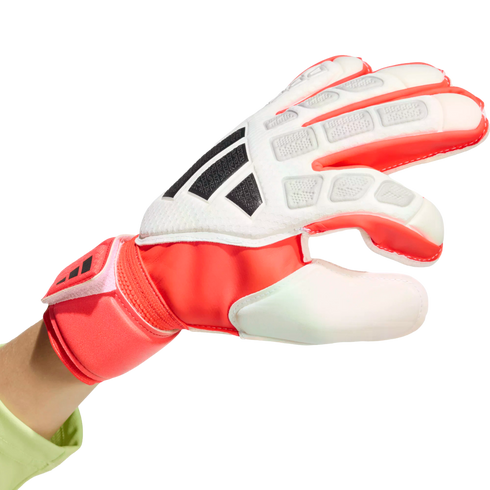 A red and white Adidas goalkeeper glove with black stripes and protective padding, shown against a black background.