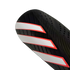 Close-up of a black athletic shin guard featuring three diagonal white stripes with red outlines.