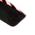 Close-up of a black shin guard with red and white accents, featuring perforated and ridged textures against a black background.