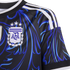 Close-up of a black Argentina soccer jersey with blue abstract patterns, three white shoulder stripes, and the AFA crest topped with three stars.