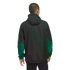 A man seen from behind wearing a black hooded jacket with green paneling on the sleeves, set against a black background.