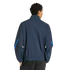 Back view of a person with dark curly hair wearing a navy blue track jacket with bright blue sleeve accents and black pants, set against a solid black background.