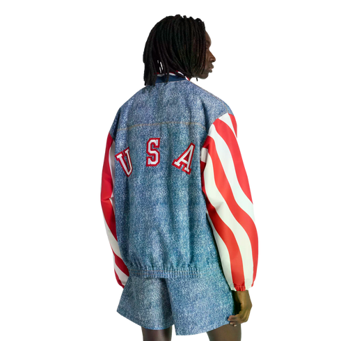 Back view of a person wearing a denim-print jacket with "USA" on the back, red and white striped sleeves, and matching shorts.