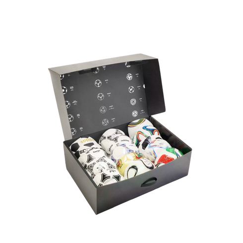 An open black box filled with diverse Adidas soccer balls, featuring historical ball designs on the inner lid.