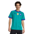 A man wearing a teal Argentina soccer jersey with purple trim, featuring the AFA crest and FIFA World Champions patch, against a black background.