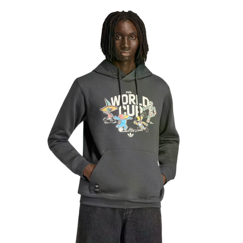A Black man with dreadlocks wears a grey Adidas FIFA World Cup hoodie with colorful cartoon mascots on the chest, standing against a black background.