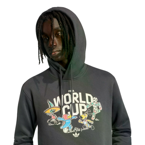 A young man with dreadlocks wearing a dark grey Adidas FIFA World Cup hoodie with colorful cartoon graphics on the front.