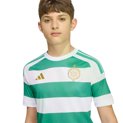 A young boy wearing a green and white striped Celtic FC soccer jersey with gold logos, set against a plain white background.
