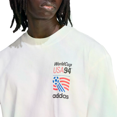 A person wearing a white Adidas t-shirt with a World Cup USA 94 graphic on the chest.