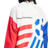 A close-up view from behind of a person wearing a white, red, and blue athletic jacket against a black background. The text "Making Soccer History" is printed in black on the white upper back. The lower back features red horizontal stripes on the left and