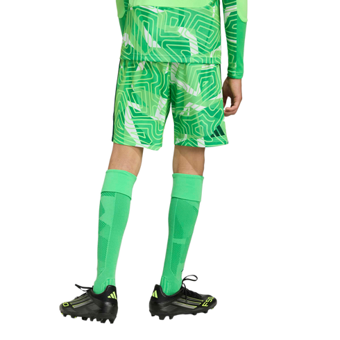 Rear view of a person wearing a green patterned soccer kit, tall green socks, and black and neon yellow soccer cleats against a light gray background.