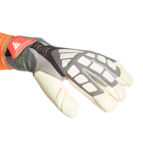 An Adidas goalkeeper glove in grey and white with orange accents, featuring the brand logo and "URG 2.0+" text on the thumb, worn on a hand against a black background.
