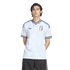 A man in a white Adidas Italy jersey with blue and gold trim, standing against a black background.