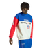 A person with short dreadlocks wearing an Adidas color-blocked "WorldCup USA 94" sweatshirt in blue, white, and red, paired with matching blue track pants, against a solid black background.