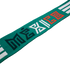 A teal knit scarf with stylized, geometric "MÉXICO" text in dark green, white, and red. Two white stripes appear at each end. Set against a solid black background.