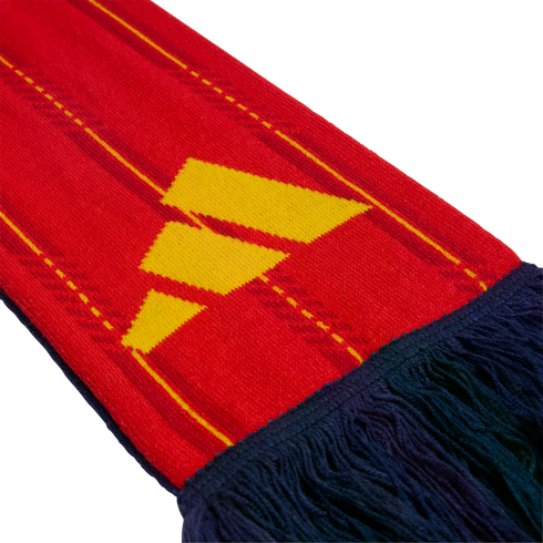 Close-up of a red knit scarf featuring yellow stripes and a yellow Adidas logo, finished with dark blue fringe tassels.