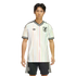 A man models a white Japan football jersey featuring thin vertical rainbow stripes and matching black shorts against a solid black background.