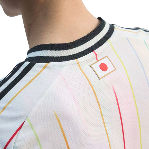 Close-up of the back of a white sports jersey with colorful pinstripes and a Japanese flag patch below a black-and-white ribbed collar.