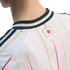 Close-up of the back of a white sports jersey with colorful pinstripes and a Japanese flag patch below a black-and-white ribbed collar.