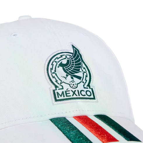 Close-up of a white cap featuring the embroidered Mexico national football team logo and green and red stripes on the brim, set against a black background.