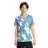 A young person wearing a blue and white star-patterned Adidas shirt with red trim and black shorts, standing against a black background.