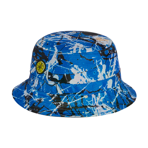 A blue bucket hat with a black and white paint splatter pattern and a small yellow citrus slice patch on the side.