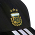 Close-up of a black cap with the gold embroidered Argentina (AFA) crest, three stars above it, and three white stripes on the brim.