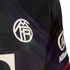 Close-up of a dark textured athletic jersey with a white circular embroidered logo on the chest and an Allianz sponsor logo on the sleeve.