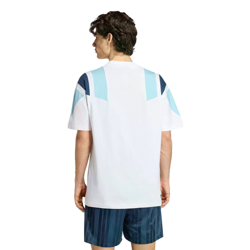 Back view of a man in a white t-shirt with blue geometric shoulder patterns and navy striped shorts against a white background.