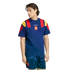 A man modeling a navy blue Adidas Spain football kit featuring a t-shirt with red and yellow shoulder panels and matching vertical-striped shorts.
