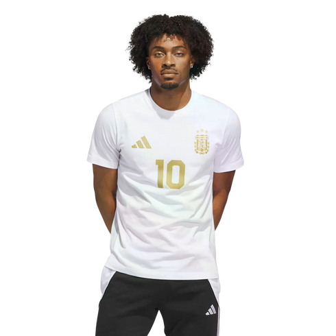 A young man with curly hair wearing a white Argentina jersey with gold number 10 and logos, standing against a black background.