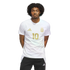 A young man with curly hair wearing a white Argentina jersey with gold number 10 and logos, standing against a black background.