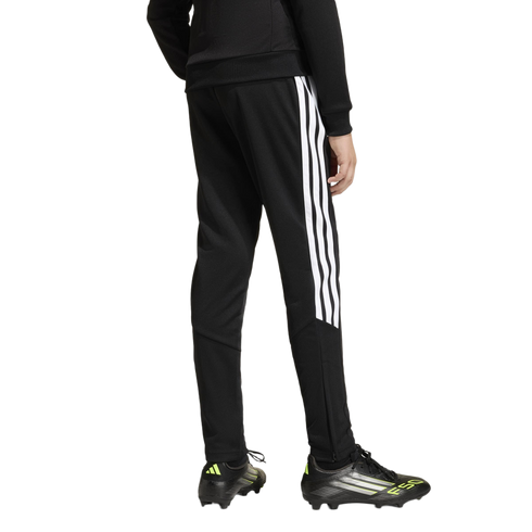 Rear view of a person in black Adidas track pants with white stripes and black F50 soccer cleats with neon accents on a white background.