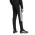 Rear view of a person in black Adidas track pants with white stripes and black F50 soccer cleats with neon accents on a white background.