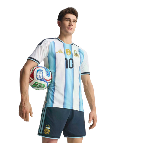 Man in a blue and white striped Argentina soccer jersey with number 10, holding a football under his arm against a black background.