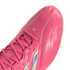 A close-up shot of a bright pink Adidas soccer cleat against a white background, showcasing the laces and textured upper material.