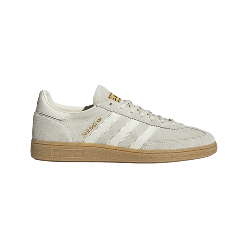 A light grey suede Adidas sneaker featuring white stripes, a gum sole, and "MESSI" in gold lettering on the side.