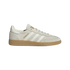 A light grey suede Adidas sneaker featuring white stripes, a gum sole, and "MESSI" in gold lettering on the side.