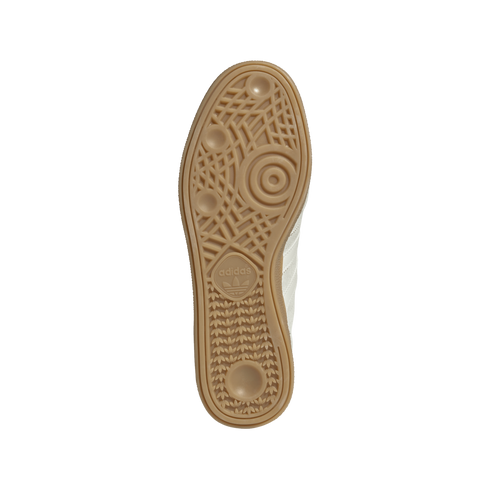 Underside of a tan rubber Adidas sneaker sole. The gum outsole features a complex geometric tread pattern with the Adidas trefoil logo, presented against a plain white background.