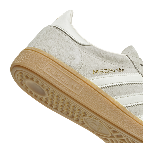 Close-up of a grey suede Adidas sneaker featuring gold "MESSI" branding and a gum rubber outsole.