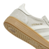 Close-up of a grey suede Adidas sneaker featuring gold "MESSI" branding and a gum rubber outsole.