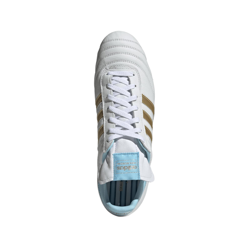 Top-down view of a white leather Adidas soccer shoe with gold stripes and light blue accents on a black background.
