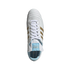 Top-down view of a white leather Adidas soccer shoe with gold stripes and light blue accents on a black background.