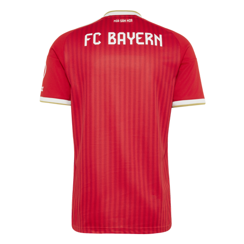 The back of a red FC Bayern soccer jersey with white lettering and gold-and-white trim on the collar and sleeves. Subtle vertical red stripes are visible on the fabric.