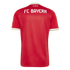 The back of a red FC Bayern soccer jersey with white lettering and gold-and-white trim on the collar and sleeves. Subtle vertical red stripes are visible on the fabric.